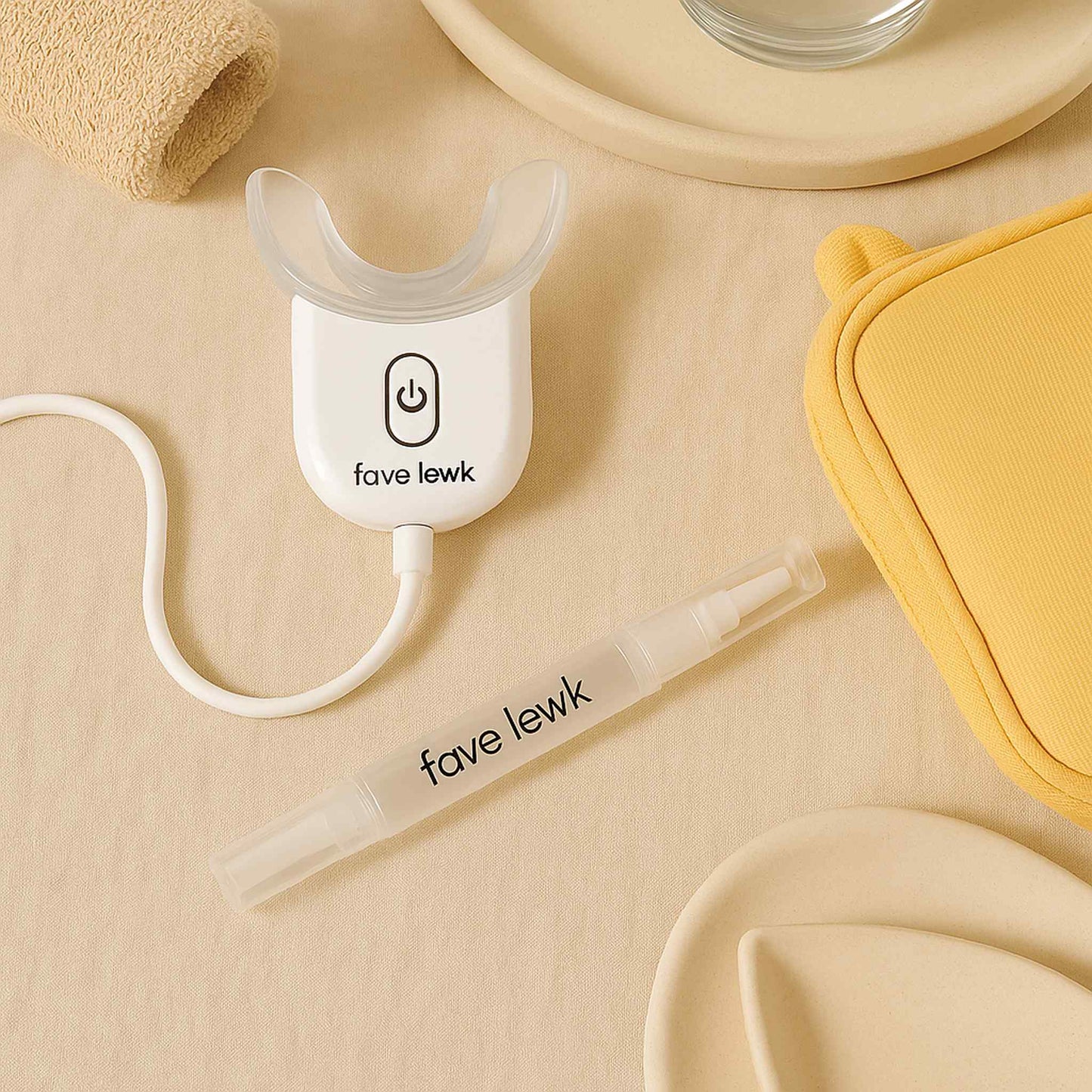 Flat lay of Fave Lewk LED Smile Kit for at-home teeth whitening with mouth tray and whitening pen