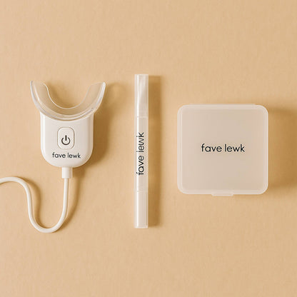 Flat lay of Fave Lewk Smile Kit with LED light, teeth whitening gel pen, and travel case for at-home or on-the-go whitening routine