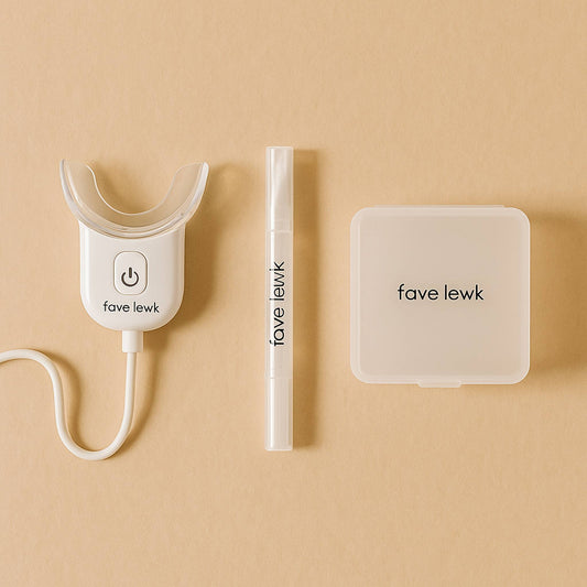 Flat lay of Fave Lewk Smile Kit with LED light, teeth whitening gel pen, and travel case for at-home or on-the-go whitening routine